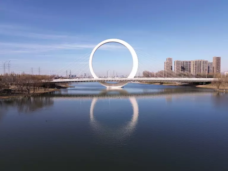 Moderne Brücke mit kreisförmigem Pfeiler über einen Fluss in einer Metropole