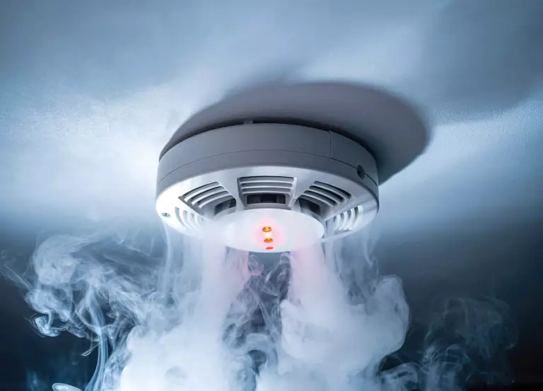Ein an der Decke installierter Rauchwarnmelder löst aufgrund von dichtem Rauch Alarm aus